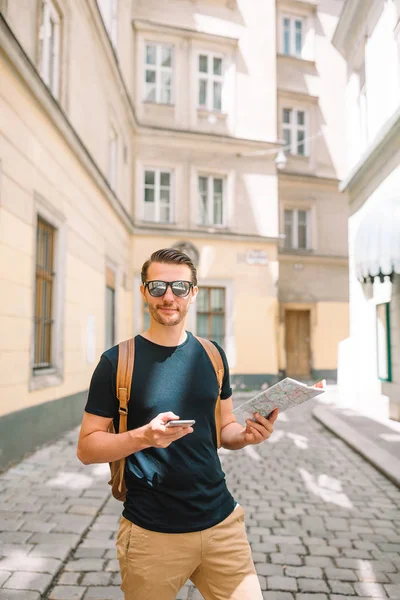 Muž turisty s mapou města a batoh v Evropské ulici. — Stock fotografie