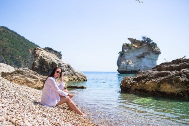Plajda uzanan kadın yaz tatilinin tadını çıkarıyor ve denize bakıyor.