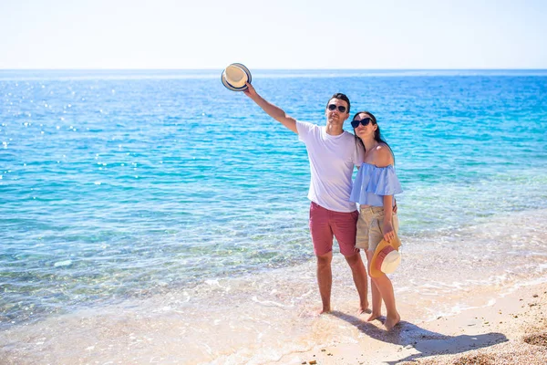 Imagen de pareja feliz en gafas de sol en la playa —  Fotos de Stock