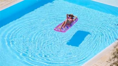 Büyük yüzme havuzunda bikini hava şilte genç kadın