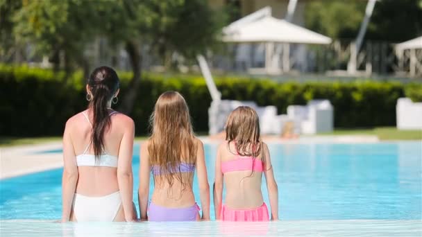 Мама з двома дітьми насолоджуються літньою відпусткою в розкішному басейні. — стокове відео
