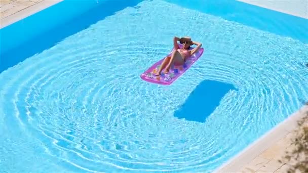 Молодая женщина в надувном матраце в бикини в большом бассейне — стоковое видео