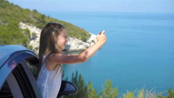 Kleines Mädchen auf Urlaubsreise mit dem Auto. Sommerurlaub und Autoreisekonzept — Stockvideo