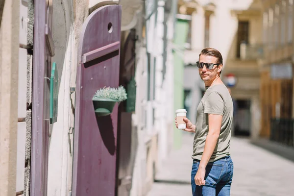 Happy young urban man drinking coffee in european city outdoors — Stock Photo, Image