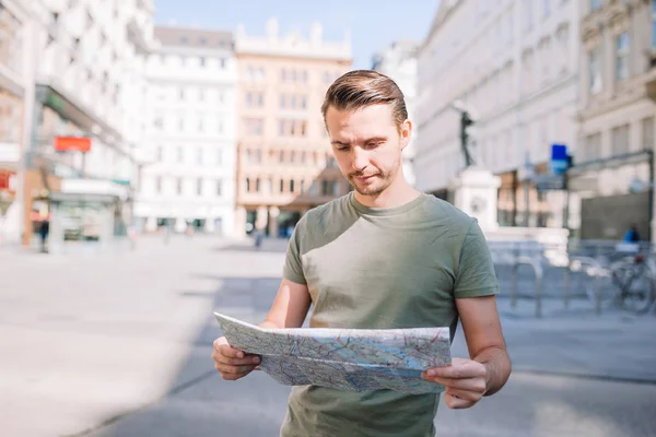 Muž turisty s mapou města a batoh v Evropě ulici. Kavkazská chlapec s mapou Evropského města. — Stock fotografie