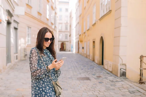 Женщина разговаривает на смартфоне в городе. Молодой привлекательный турист на открытом воздухе в итальянском городе — стоковое фото