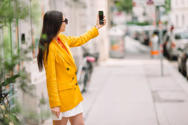 Vrouw praat door haar smartphone in de stad. Jonge aantrekkelijke toeristische buitenshuis in Italiaanse stad — Stockfoto