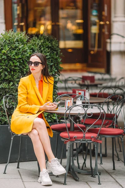 Belle femme assise dans un café en plein air à la ville européenne — Photo