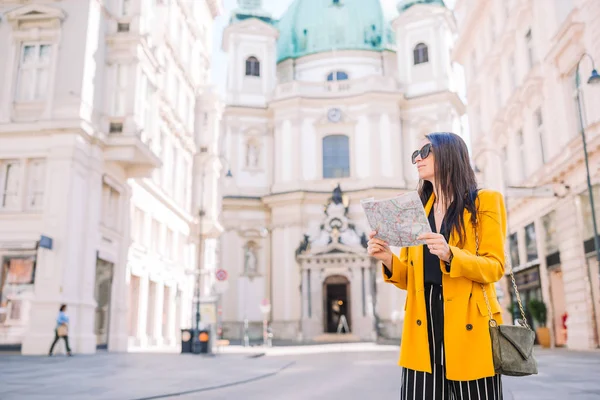 Mujer joven con un mapa de la ciudad. Viajar chica turística con mapa en Viena al aire libre durante las vacaciones en Europa . — Foto de Stock