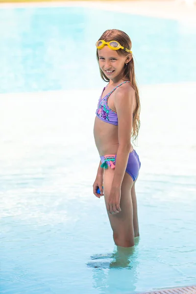 Pequena menina adorável na piscina exterior — Fotografia de Stock