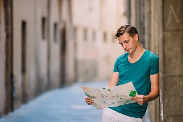 Young man with a city map in european city. — Stock Photo, Image