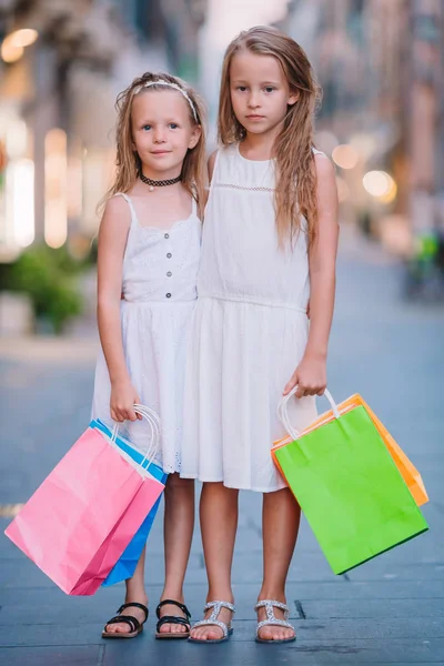 Alışveriş torbaları ile oldukça gülümseyen küçük kızlar — Stok fotoğraf