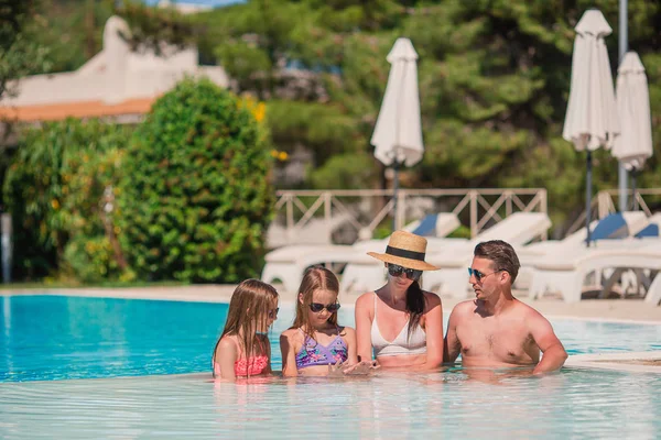 Felice famiglia di quattro persone in piscina — Foto Stock