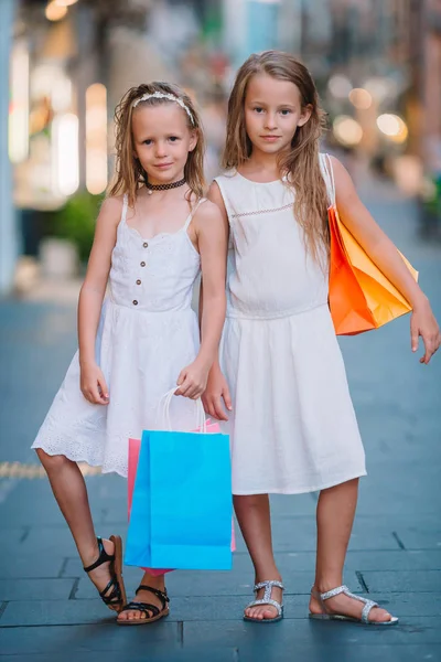 Hübsche lächelnde kleine Mädchen mit Einkaufstüten — Stockfoto