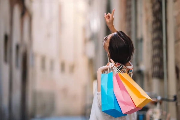 Chica joven con bolsas de compras en la calle estrecha de Europa . —  Fotos de Stock