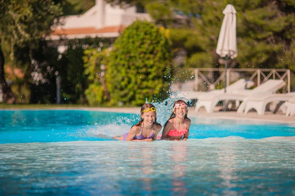 Adorables niñas jugando en la piscina al aire libre de vacaciones —  Fotos de Stock