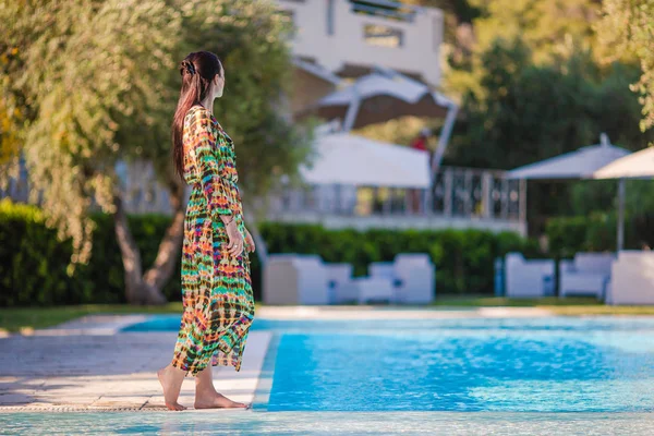 Mulher relaxante na piscina em um resort de hotel de luxo desfrutando de férias perfeitas na praia — Fotografia de Stock