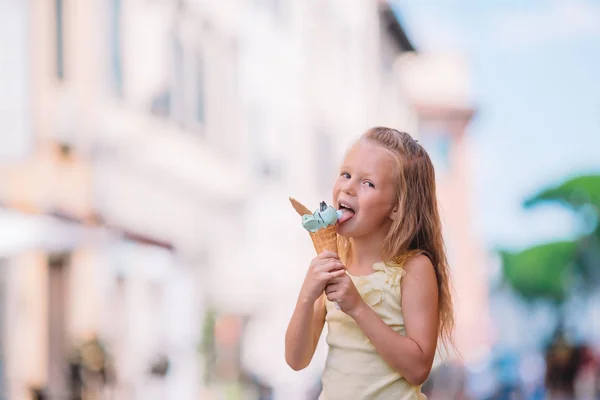 Adorable little girl eating ice-cream outdoors at summer. — Stock Photo, Image