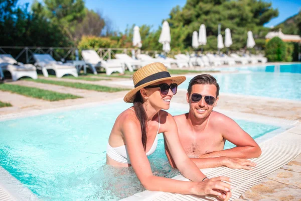 Cheerful couple resting in a swimming pool — Stock Photo, Image