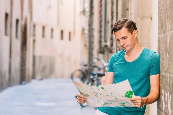 Jonge man met een plattegrond van de stad in Europese stad. — Stockfoto