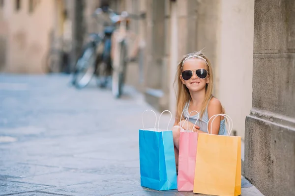 Portret van schattig meisje lopen met boodschappentassen buitenshuis in Europese stad. — Stockfoto