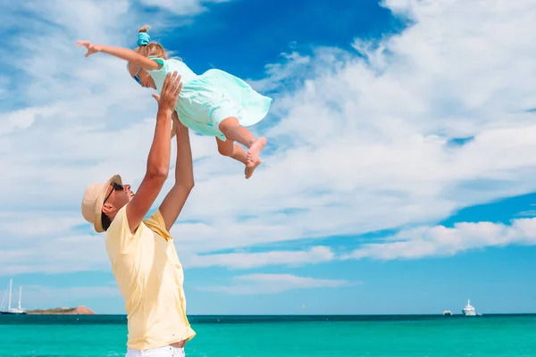 Маленька дівчинка і щасливий тато розважаються під час пляжних канікул — стокове фото
