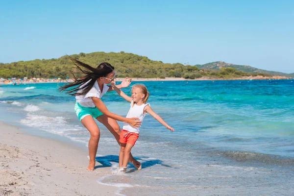 Beautiful mother and daughter at the beach enjoying summer vacation. — Stock Photo, Image