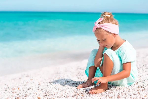 Портрет очаровательной маленькой девочки на пляже на ее летних каникулах — стоковое фото