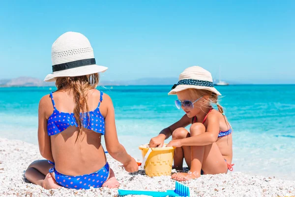 Zwei kleine glückliche Mädchen haben viel Spaß am tropischen Strand beim gemeinsamen Spielen — Stockfoto