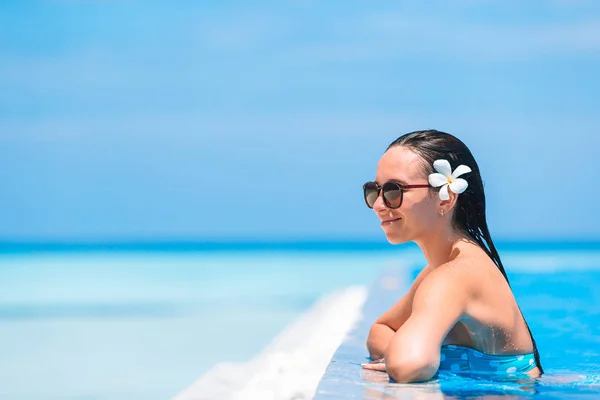 Jovem mulher bonita desfrutando de férias de verão na piscina de luxo — Fotografia de Stock