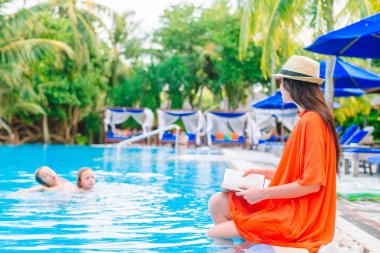 Genç kadın kitap okuma sırasında tropikal Maldivlere beach