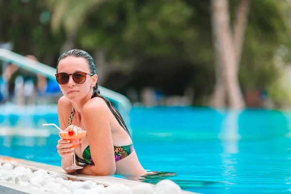 Jovem mulher bonita desfrutando de férias de verão na piscina de luxo — Fotografia de Stock