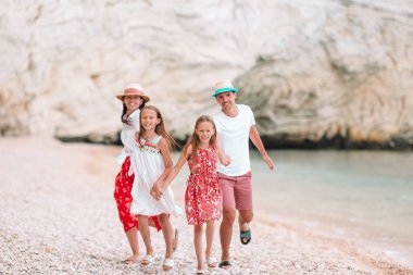Kumsalda çocukları olan mutlu bir aile.