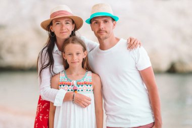 Yaz tatilinde beyaz plajda genç bir aile.
