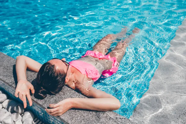 Young beautiful woman enjoying summer vacation in luxury swimming pool — Stock Photo, Image