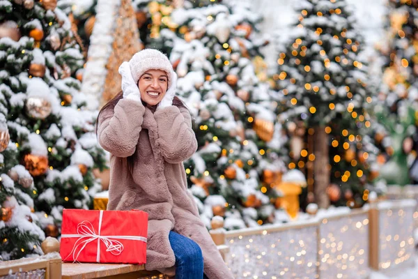 La muchacha feliz cerca de la rama del abeto en la nieve para un nuevo año. —  Fotos de Stock