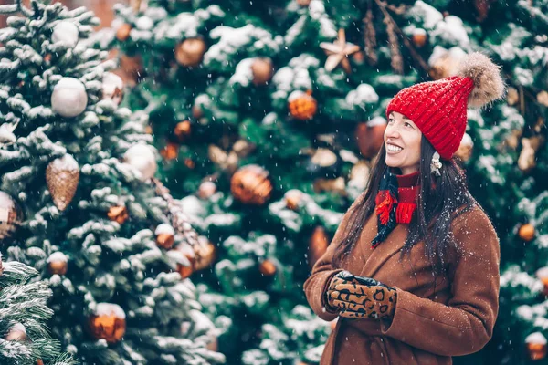 Lykkelig jente nær gran-tre-grein i snø i nyttår. – stockfoto