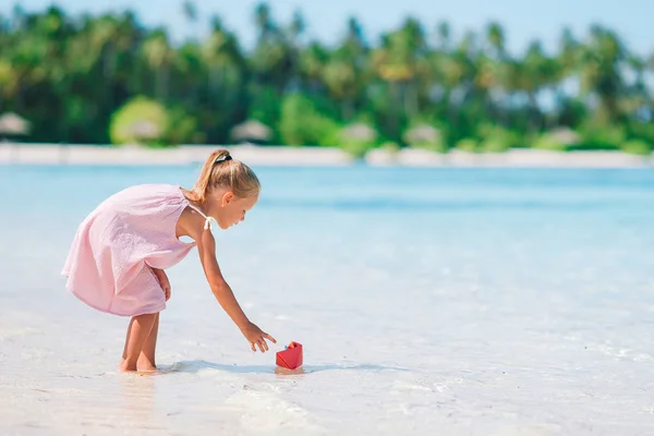 Malá rozkošná dívka hraje na pláži s míčem — Stock fotografie