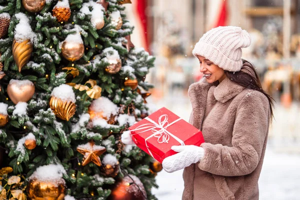 La muchacha feliz cerca de la rama del abeto en la nieve para un nuevo año. —  Fotos de Stock