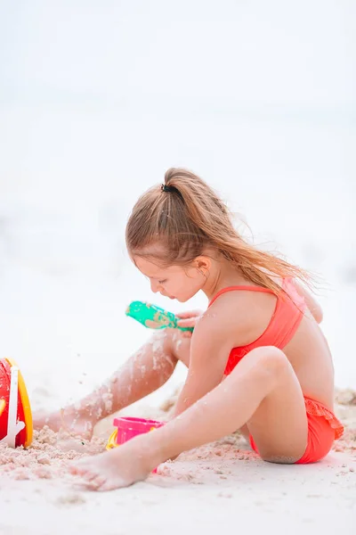 Kleines entzückendes Mädchen spielt am Strand mit Ball — Stockfoto