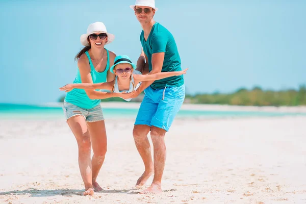 Yaz tatilinde beyaz plajda genç bir aile. — Stok fotoğraf