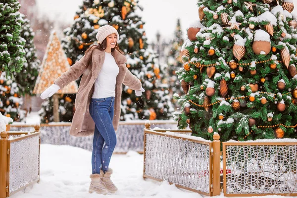 Happy girl near fir-tree branch in snow for New year. — Stock fotografie