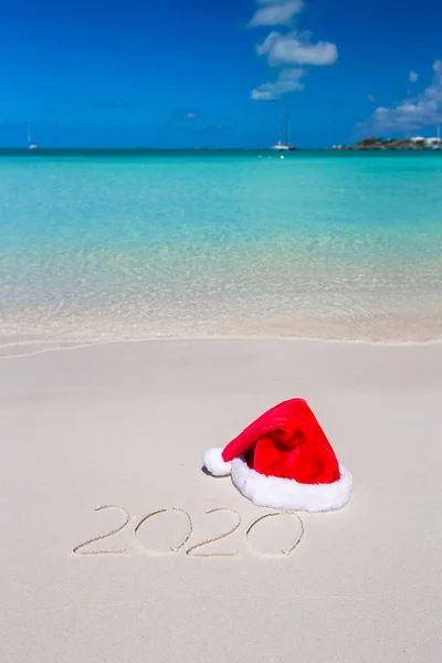 2016 written on tropical beach white sand with xmas hat — Stock Photo, Image