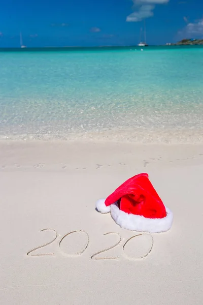 2016 escrito en la playa tropical de arena blanca con sombrero de Navidad —  Fotos de Stock