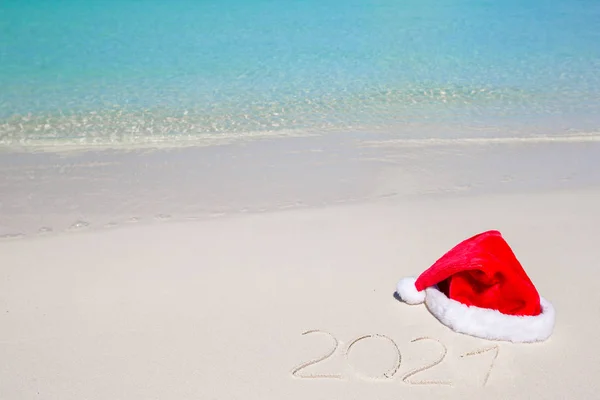 2016 escrito en la playa tropical de arena blanca con sombrero de Navidad —  Fotos de Stock