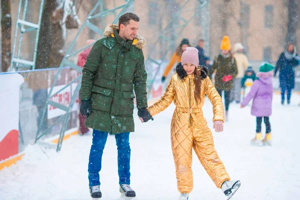 Giovane papà e adorabile bambina si divertono sulla pista di pattinaggio all'aperto — Foto Stock