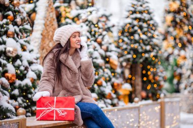Mutlu kız yılbaşı için karların içinde köknar ağacı dalının yanında.