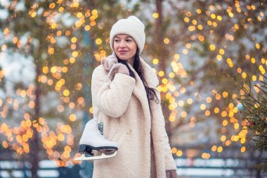 Açık havada buz pistinde paten gülümseyen genç kız