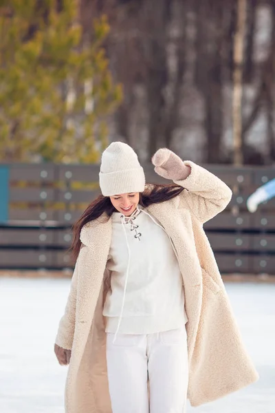 Smiling young girl skating on ice rink outdoors — Stock Photo, Image