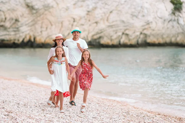 Kumsalda çocukları olan mutlu bir aile.